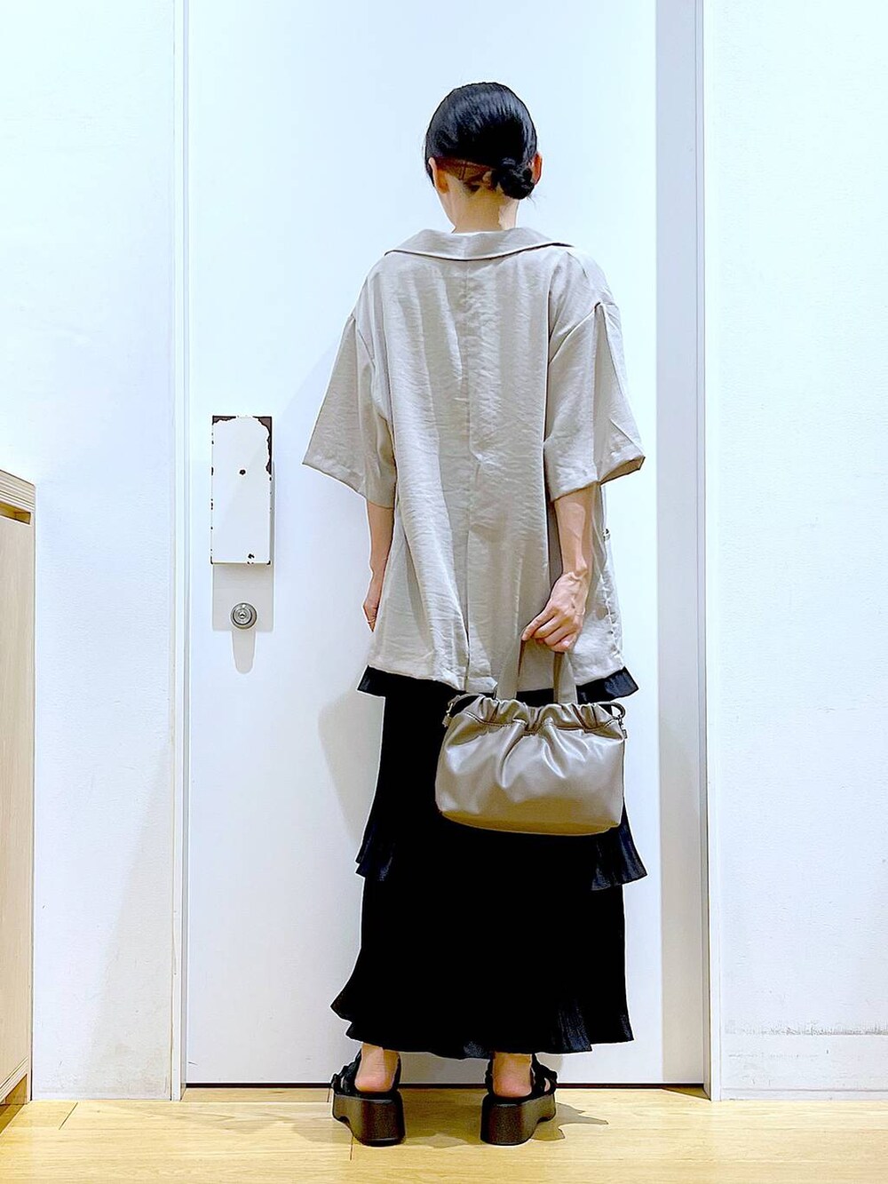 ブラック系のスカート、ブラック系のサンダル、ブラウン系のショルダーバッグを着用したレディースの夏コーディネートの5枚目の写真