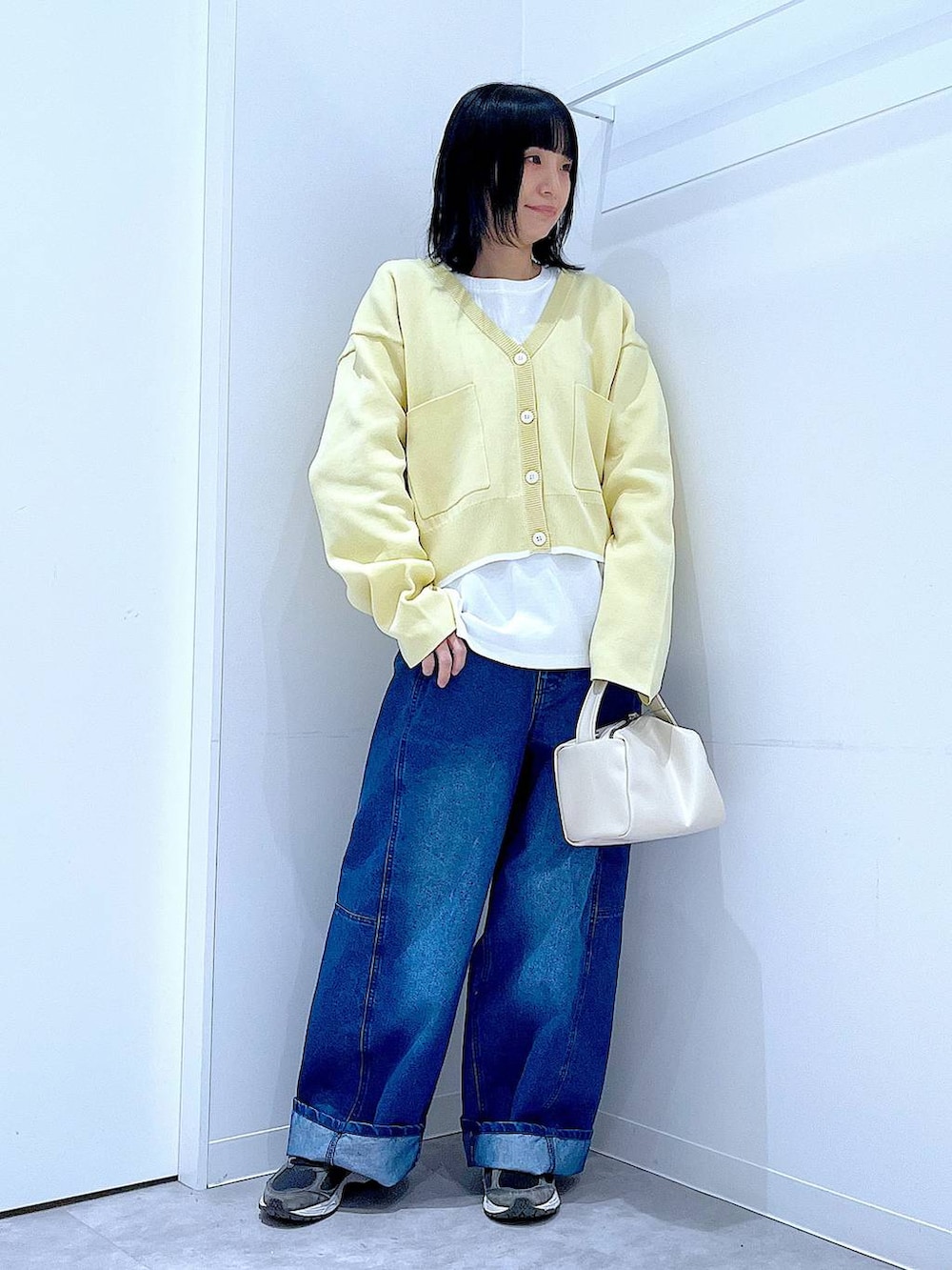 ホワイト系のショルダーバッグ、ホワイト系のTシャツ/カットソー、ブルー系のデニムパンツを着用したレディースの春コーディネートの2枚目の写真