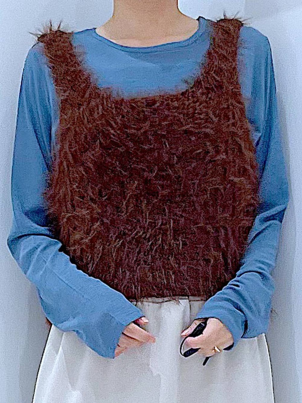 グレー系のスカート、ブルー系のTシャツ/カットソー、ブラウン系のベストを着用したレディースの秋コーディネートの7枚目の写真