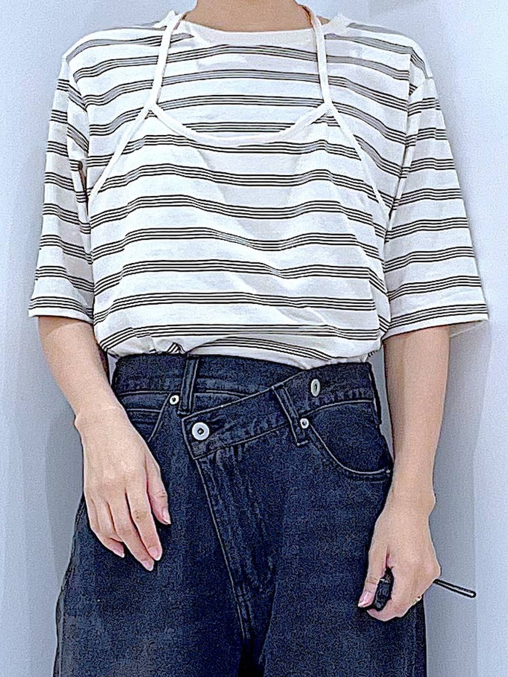 ブラック系のデニムパンツ、ホワイト系のハンドバッグ、ベージュ系のTシャツ/カットソーを着用したレディースの秋コーディネートの7枚目の写真