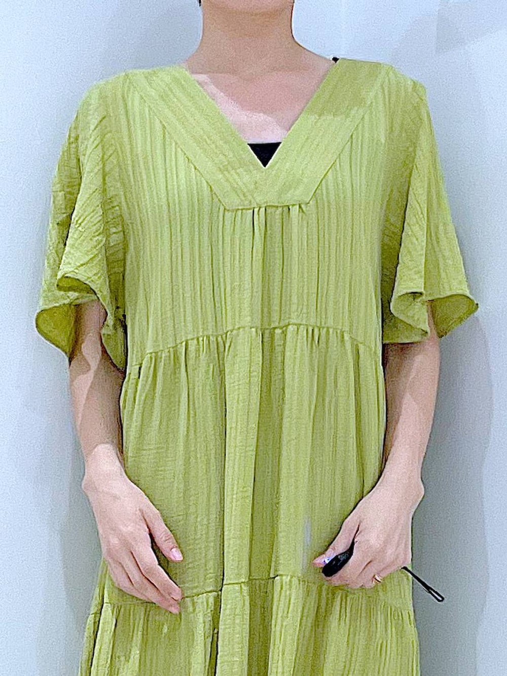 ブラック系のトートバッグ、ブラック系のサンダル、グリーン系のワンピースを着用したレディースの夏コーディネートの7枚目の写真