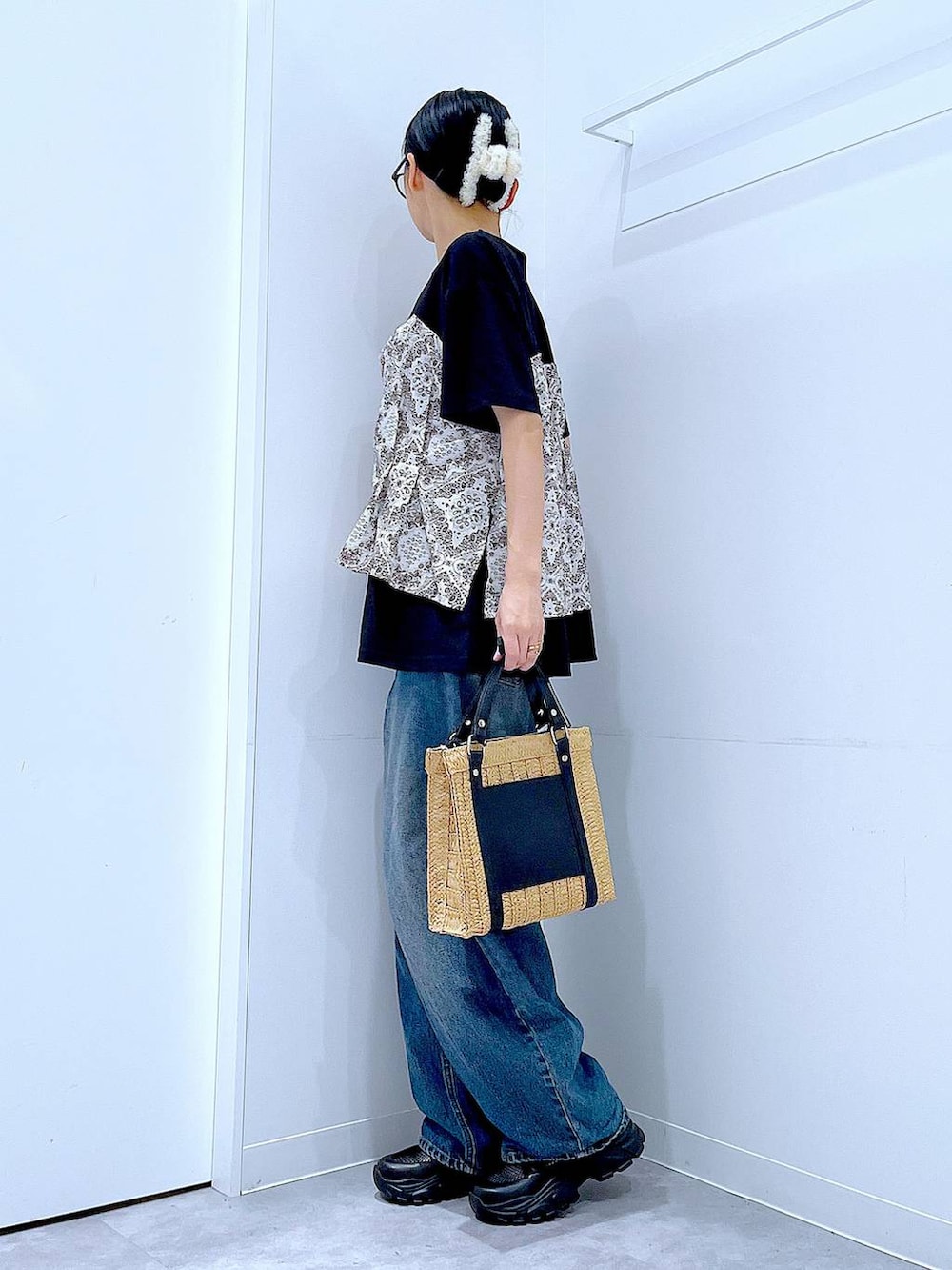 ブルー系のデニムパンツ、ブラック系のスニーカー、ブラック系のTシャツ/カットソーを着用したレディースの春コーディネートの3枚目の写真