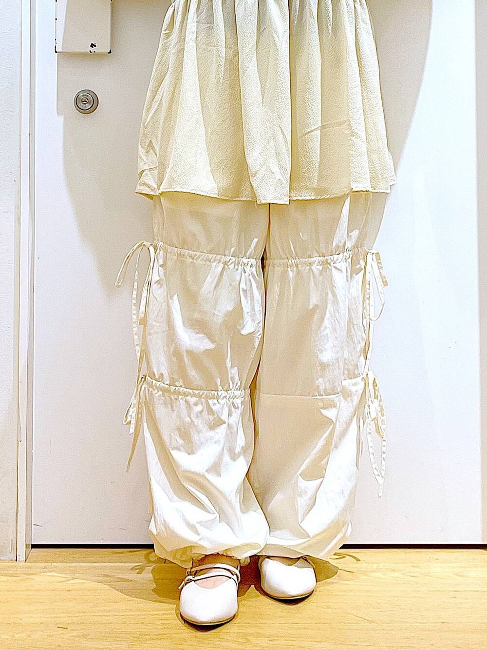 グリーン系のショルダーバッグ、ホワイト系のパンプス、ホワイト系のその他パンツを着用したレディースの秋コーディネートの8枚目の写真