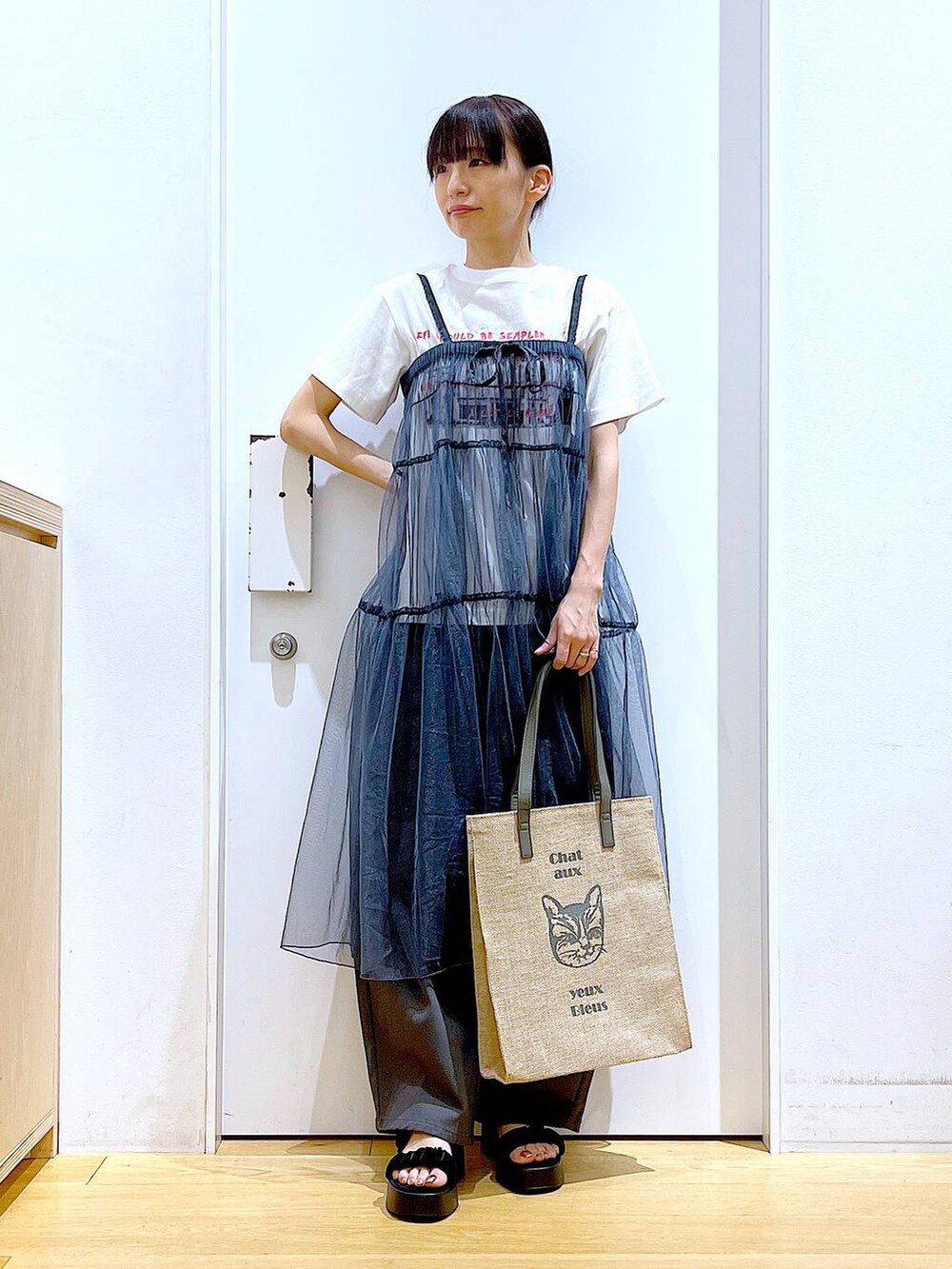 グレー系のその他パンツ、グレー系のトートバッグ、ブラック系のサンダルを着用したレディースの夏コーディネートの2枚目の写真