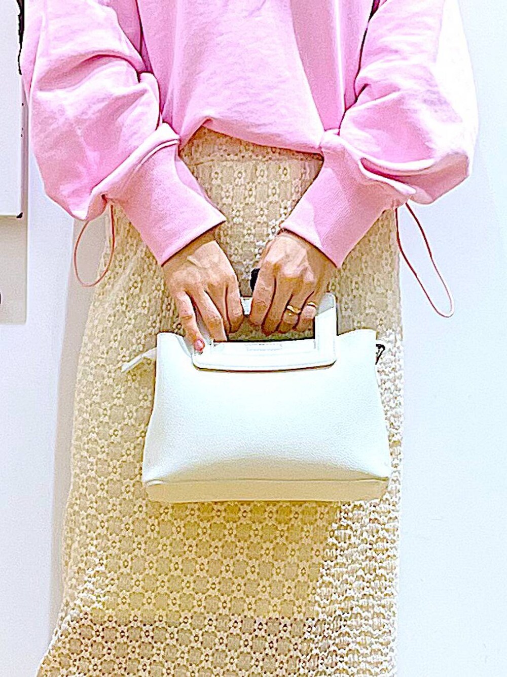 ピンク系のスウェット、ベージュ系のブーツ、ホワイト系のショルダーバッグを着用したレディースの春コーディネートの9枚目の写真