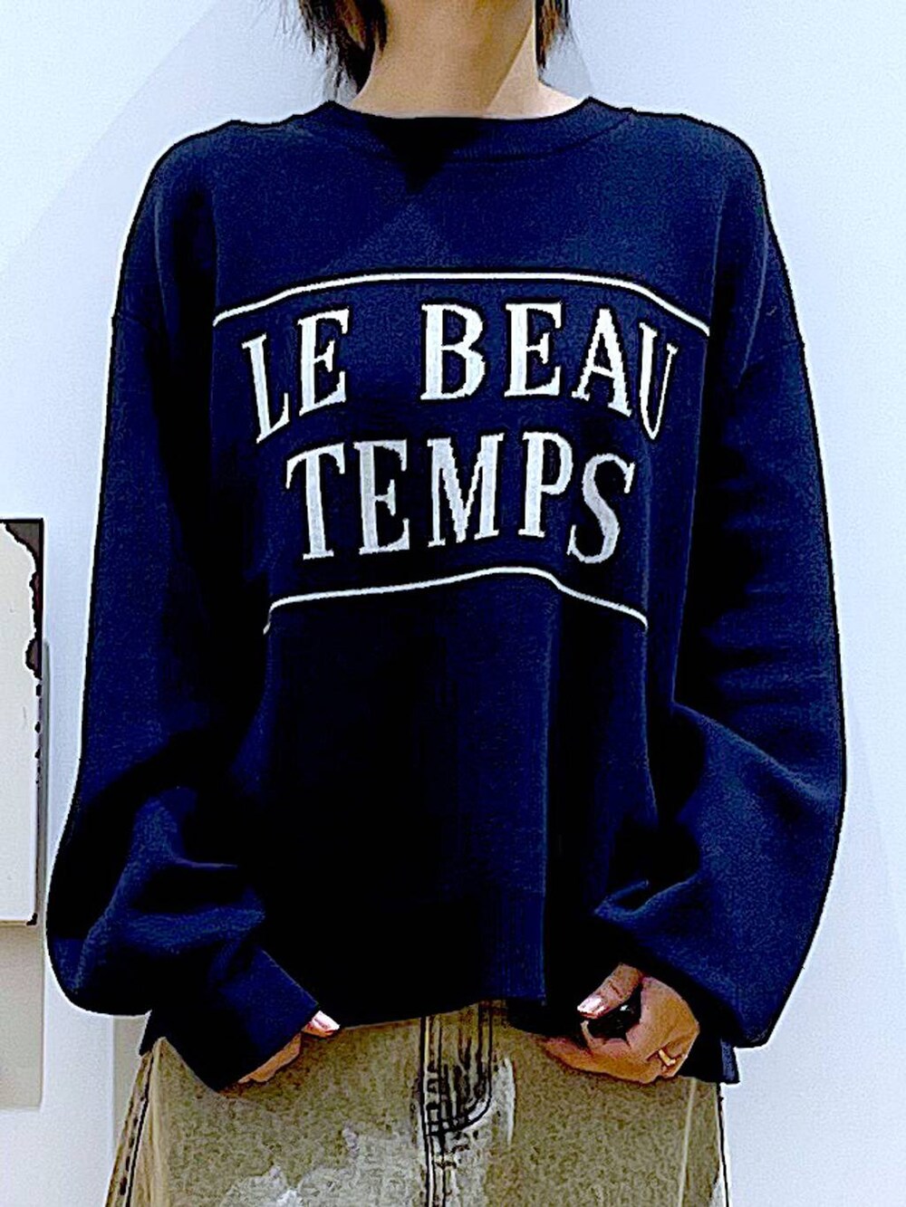 ブラック系のブーツ、ベージュ系のデニムパンツ、イエロー系のトートバッグを着用したレディースの冬コーディネートの7枚目の写真