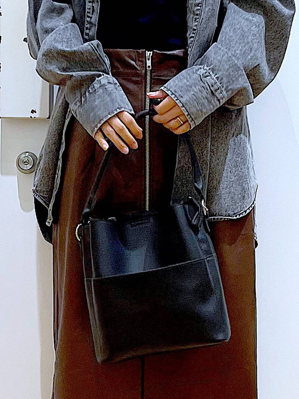 ブラウン系のスカート、ブラック系のニット/セーター、ブラック系のショルダーバッグを着用したレディースの秋コーディネートの9枚目の写真