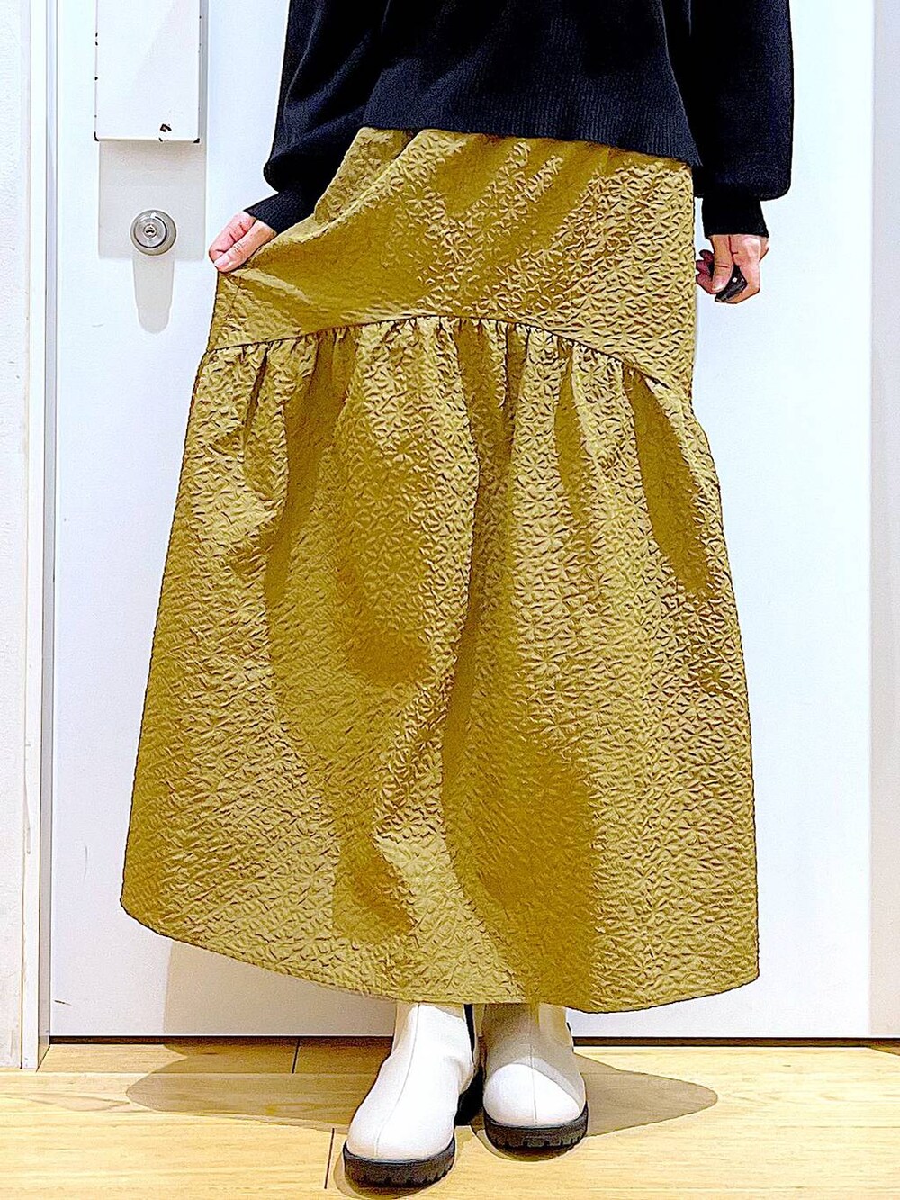 ホワイト系のショルダーバッグ、ベージュ系のブーツ、ブラック系のニット/セーターを着用したレディースの冬コーディネートの9枚目の写真