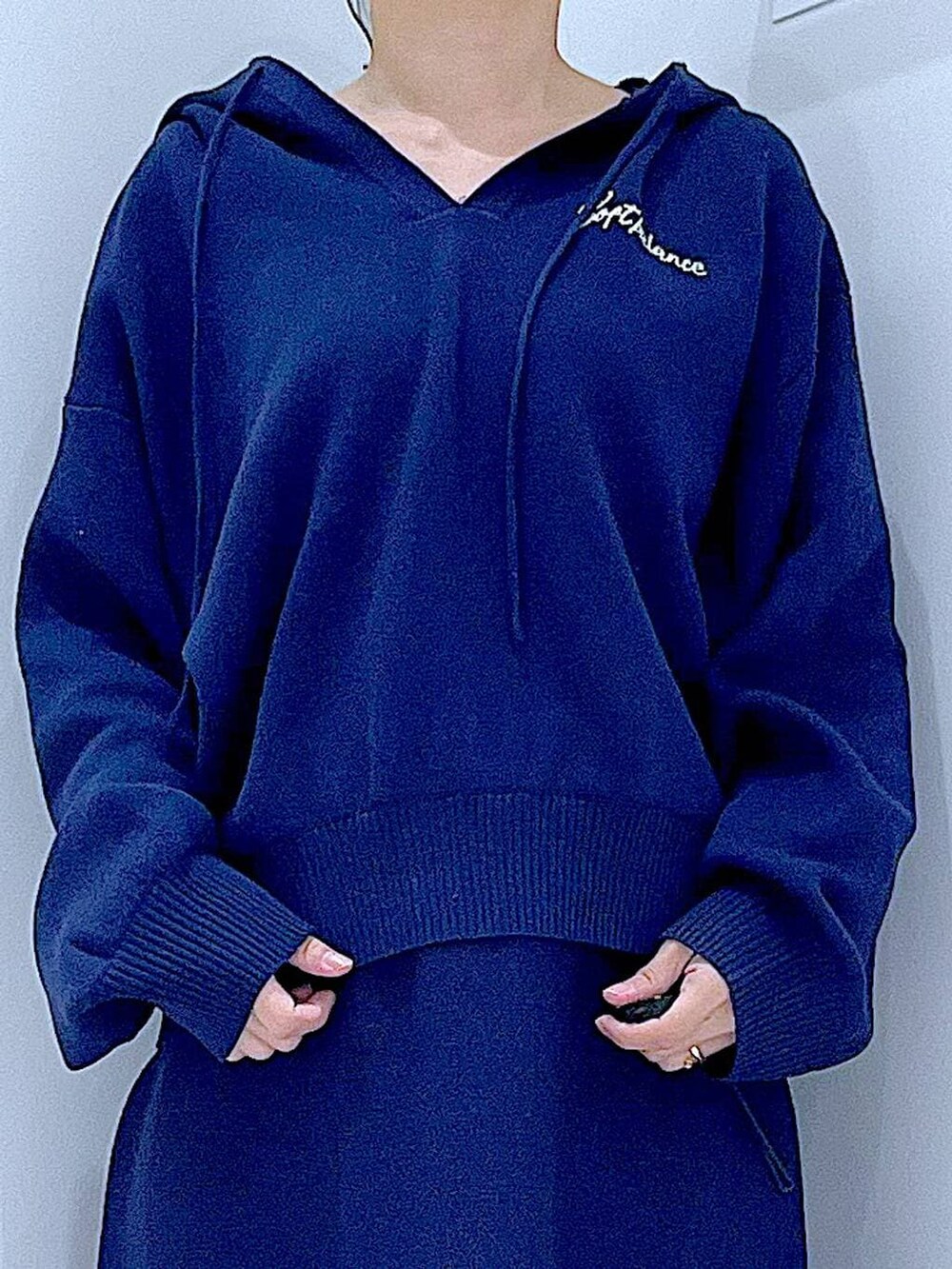 ブラック系のブーツ、ホワイト系のショルダーバッグ、ブルー系のスカートを着用したレディースの冬コーディネートの7枚目の写真