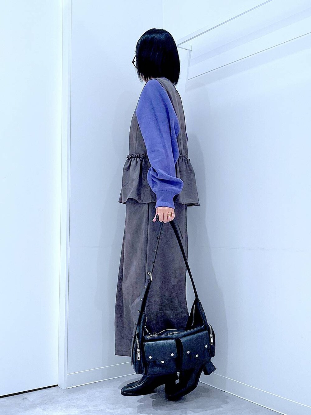 ブラック系のショルダーバッグ、ブルー系のニット/セーター、ブラック系のブーツを着用したレディースの秋コーディネートの3枚目の写真