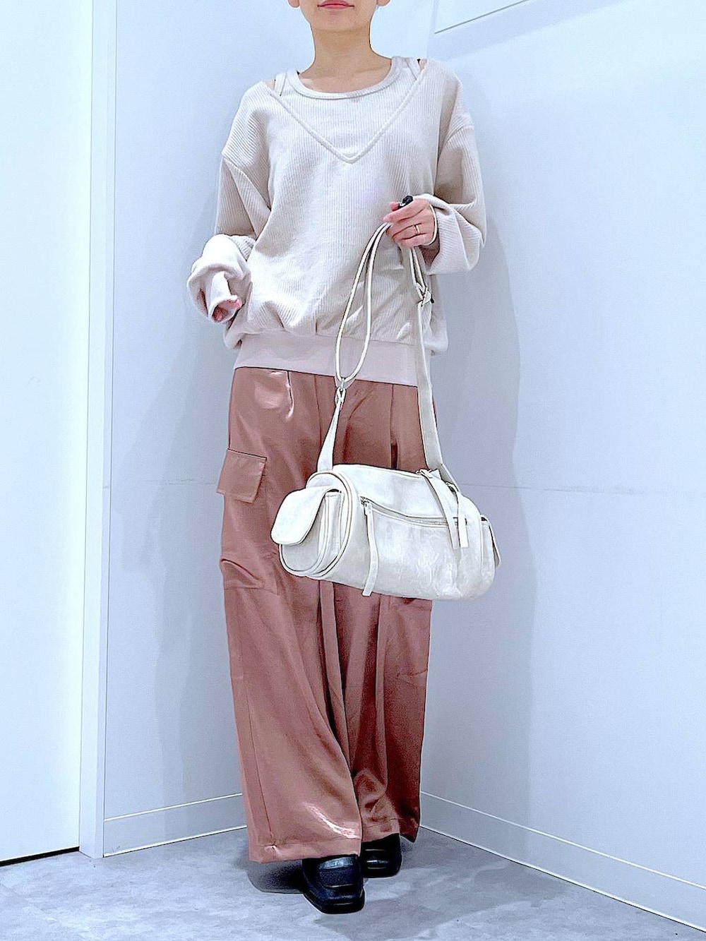 ブラック系のブーツ、ベージュ系のニット/セーター、ピンク系のカーゴパンツを着用したレディースの冬コーディネートの6枚目の写真