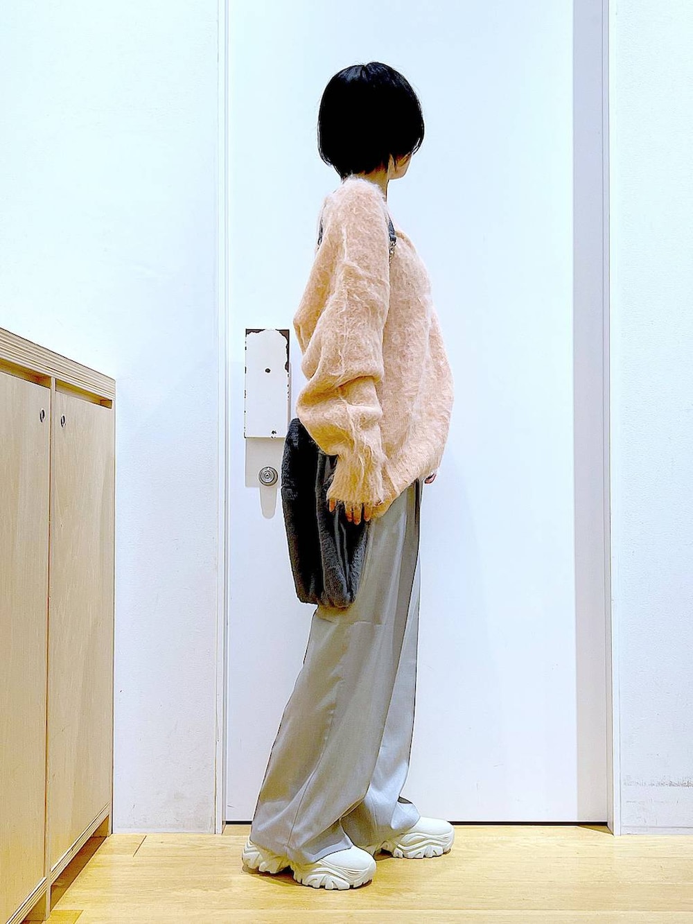 ピンク系のカーディガン/ボレロ、グレー系のショルダーバッグ、ベージュ系のブーツを着用したレディースの冬コーディネートの3枚目の写真