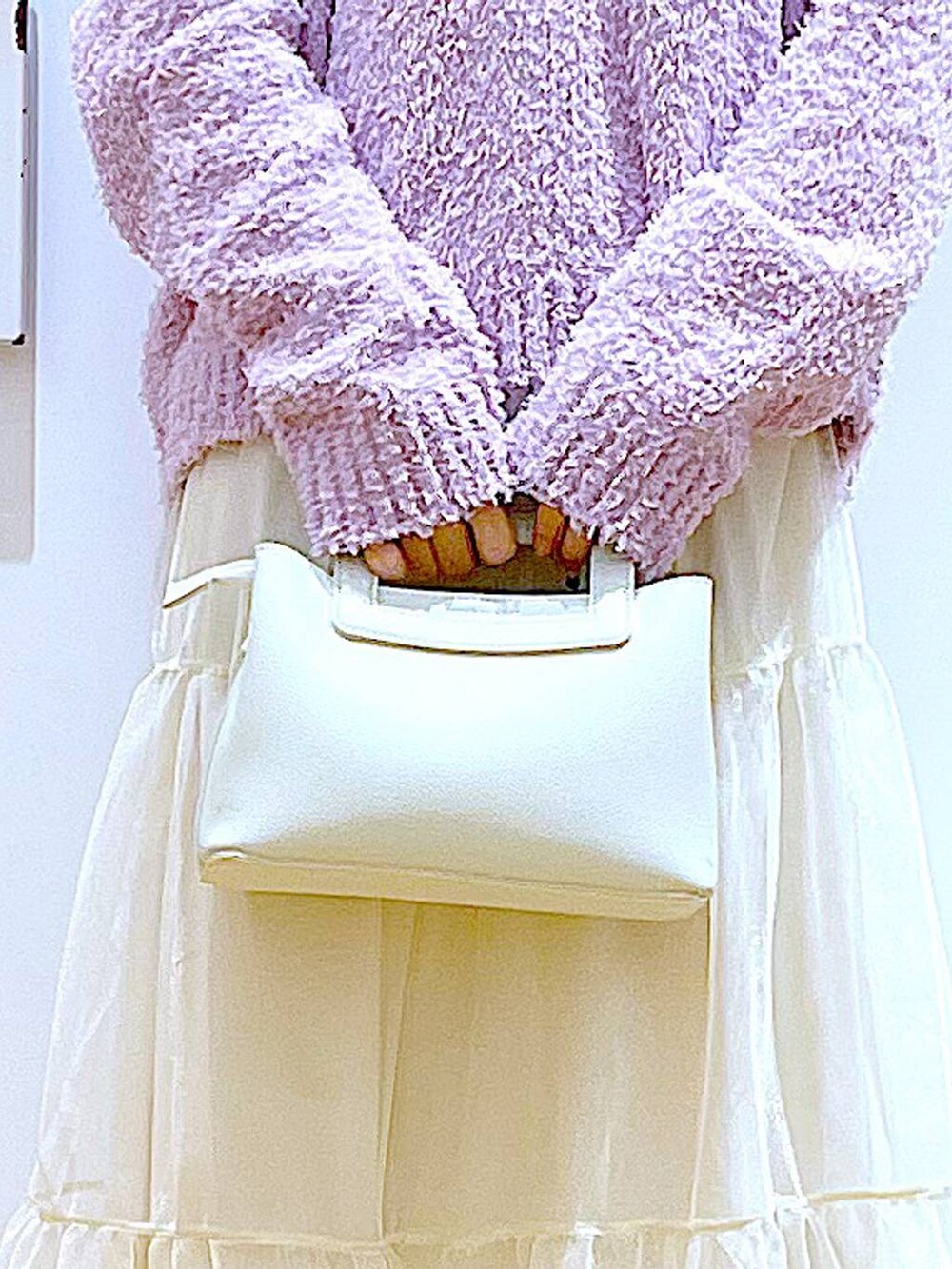 パープル系のニット/セーター、ベージュ系のブーツ、ホワイト系のショルダーバッグを着用したレディースの春コーディネートの9枚目の写真