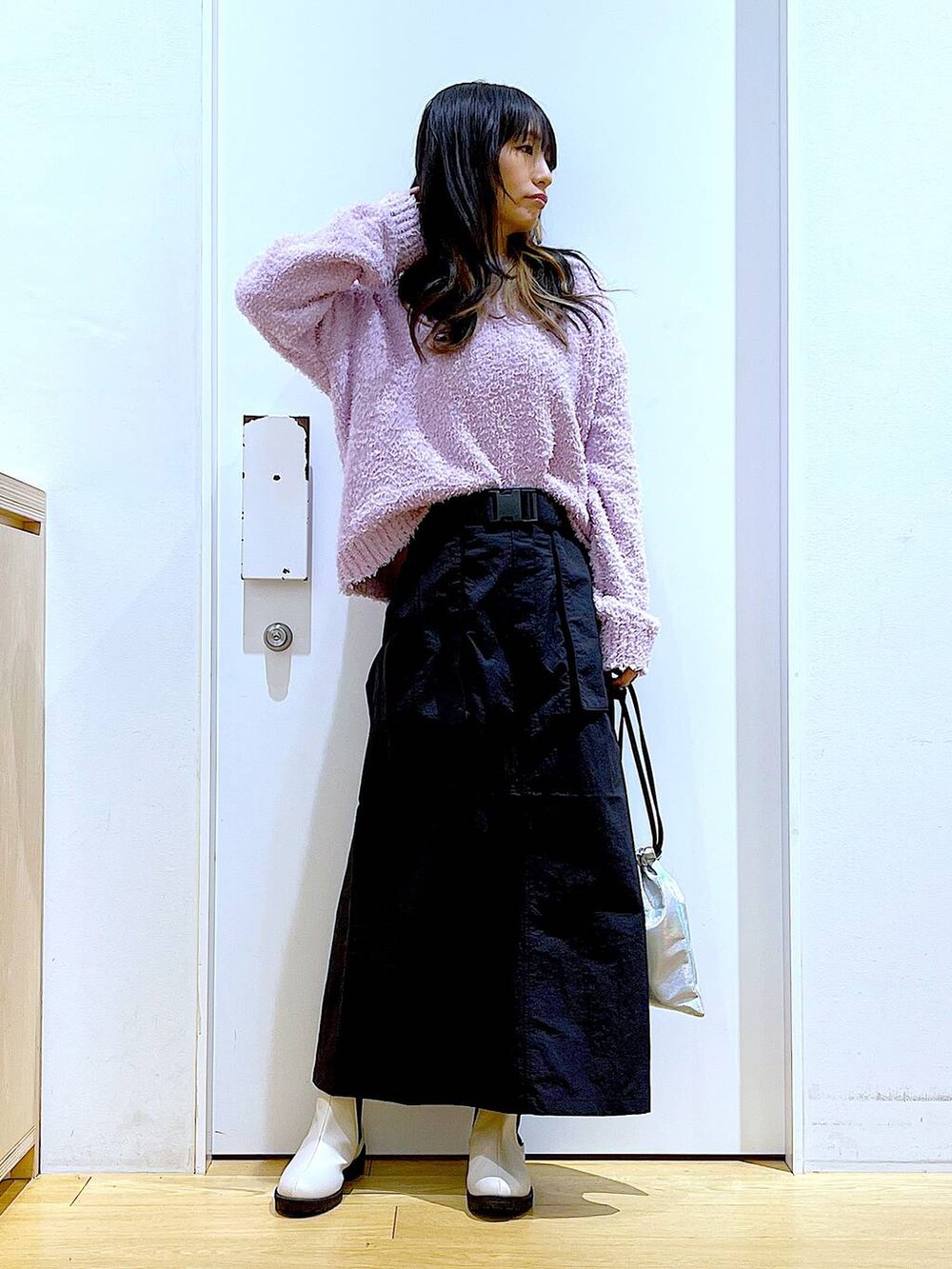 パープル系のニット/セーター、ベージュ系のブーツ、その他のショルダーバッグを着用したレディースの冬コーディネートの2枚目の写真