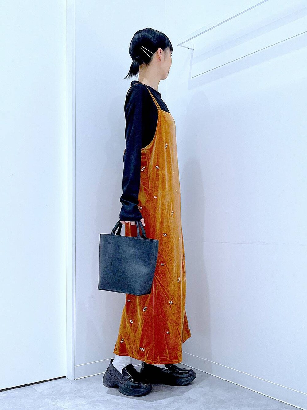 ブラック系のTシャツ/カットソー、ブラック系のショルダーバッグ、ブラック系のローファーを着用したレディースの秋コーディネートの4枚目の写真