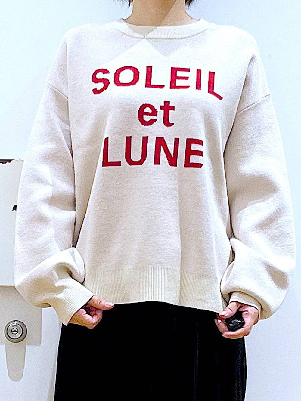 ブラック系のブーツ、ブラック系のスカート、ピンク系のトートバッグを着用したレディースの冬コーディネートの7枚目の写真