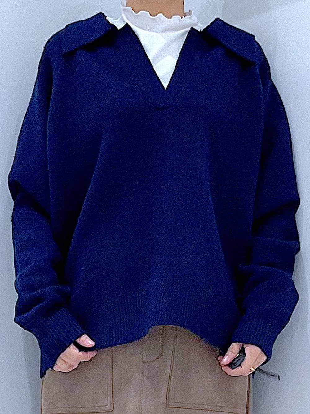 ブラック系のブーツ、ブラウン系のスカート、ベージュ系のハンドバッグを着用したレディースの冬コーディネートの7枚目の写真