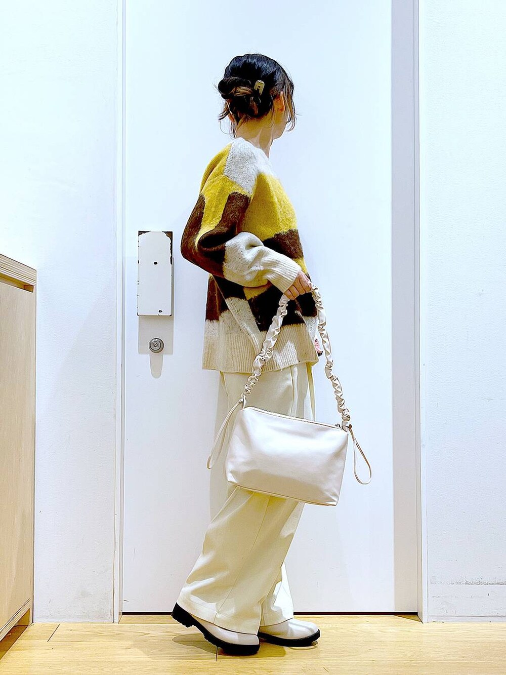 ホワイト系のショルダーバッグ、ベージュ系のブーツ、ベージュ系のその他パンツを着用したレディースの冬コーディネートの4枚目の写真