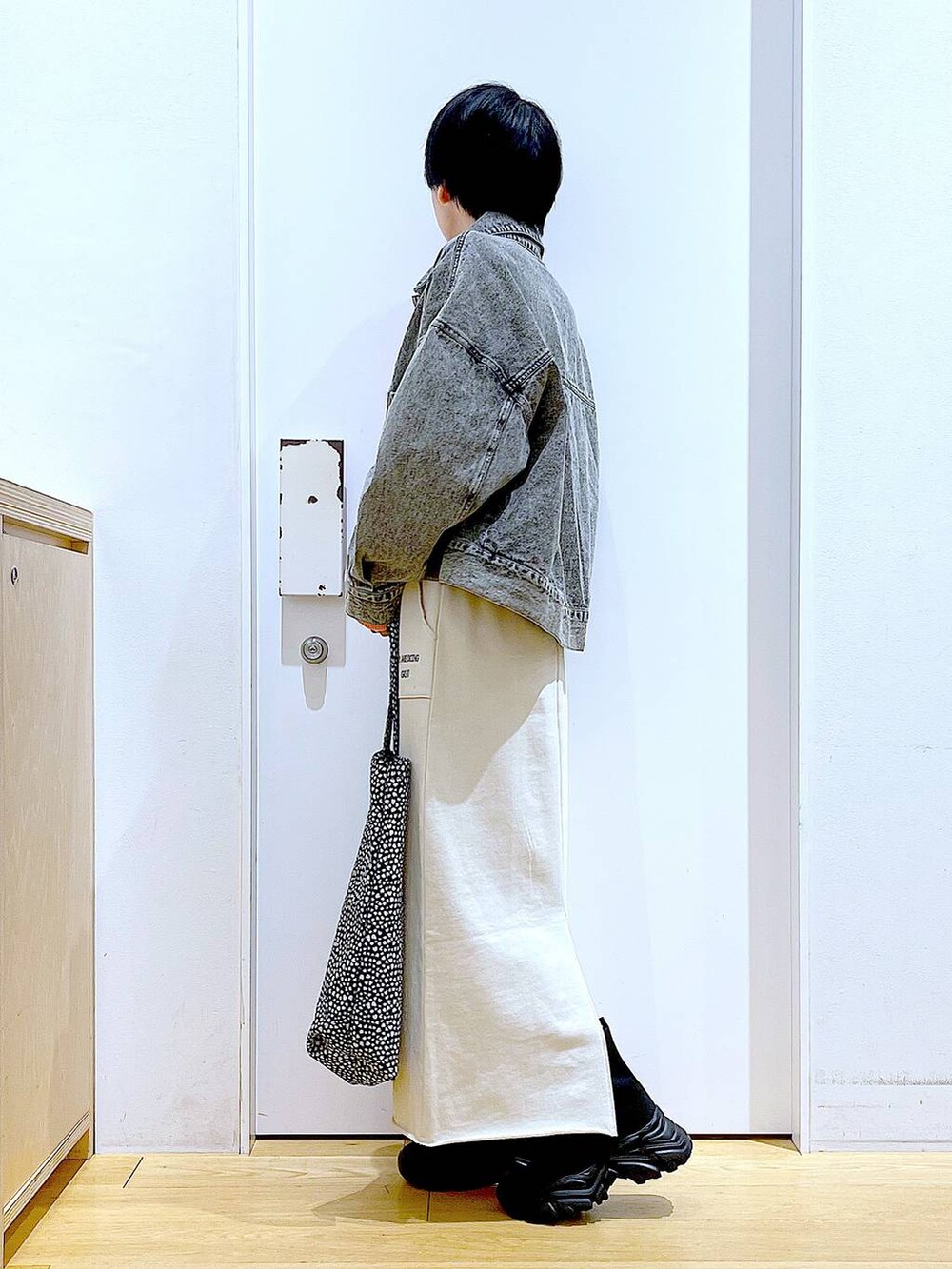 ブラック系のブーツ、その他のトートバッグ、ブラック系のデニムジャケットを着用したレディースの春コーディネートの3枚目の写真