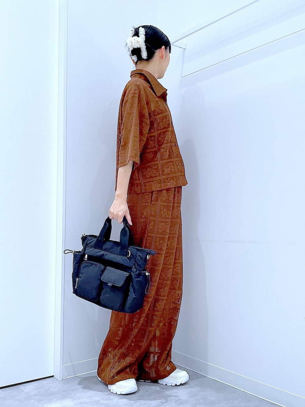 ブラック系のトートバッグ、ブラウン系のシャツ/ブラウス、ブラウン系のその他パンツを着用したレディースの春コーディネートの4枚目の写真