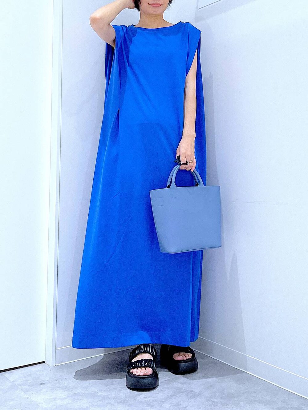 ブラック系のサンダル、ブルー系のワンピース、ブルー系のショルダーバッグを着用したレディースの夏コーディネートの6枚目の写真