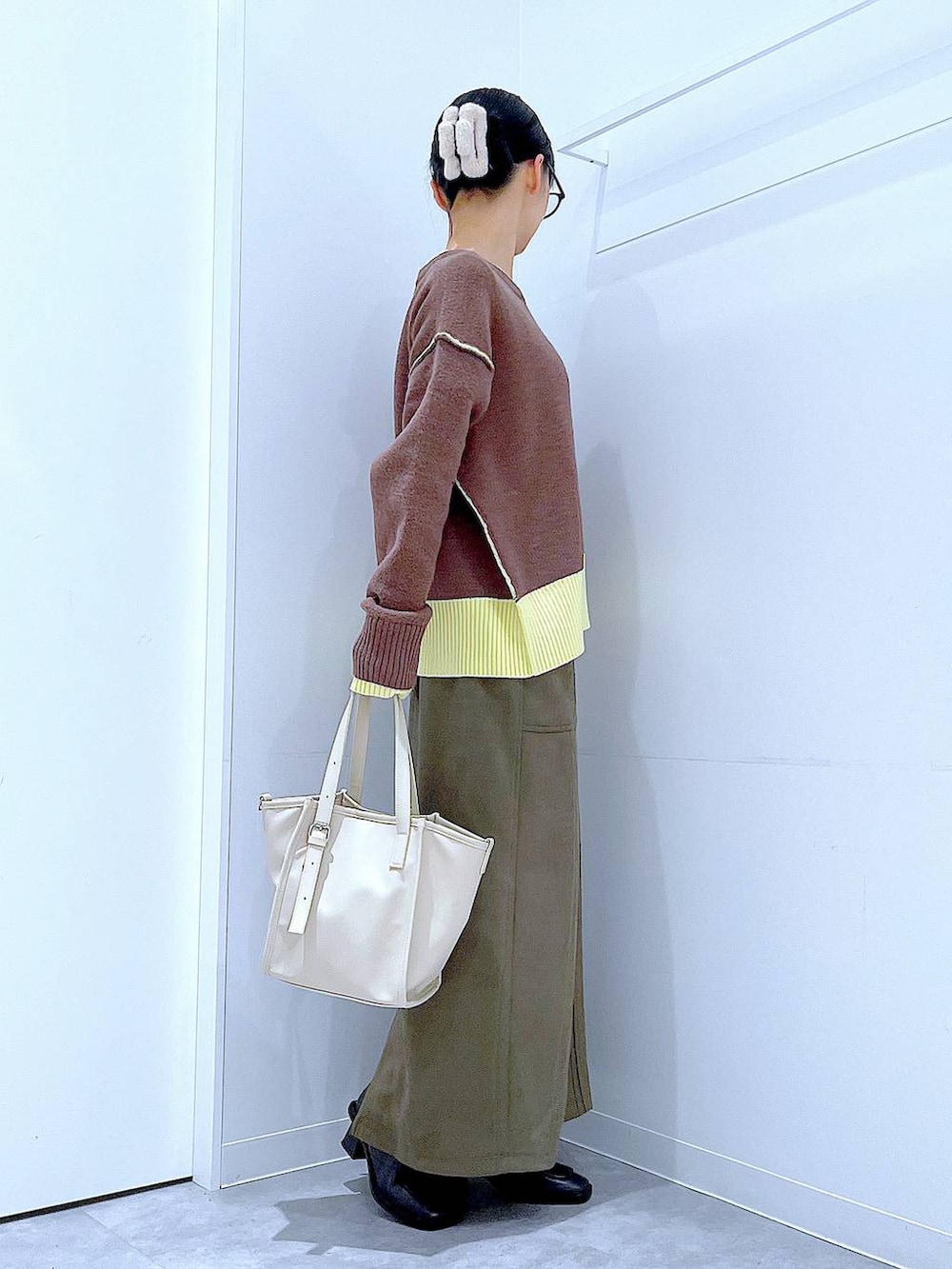 ブラック系のブーツ、グリーン系のスカート、ホワイト系のトートバッグを着用したレディースの冬コーディネートの4枚目の写真