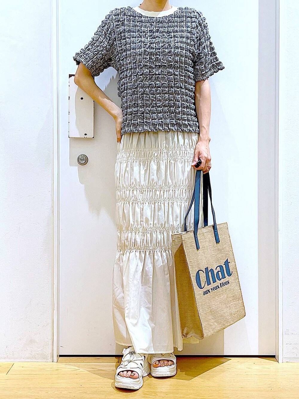 ホワイト系のサンダル、ブルー系のトートバッグ、その他のTシャツ/カットソーを着用したレディースの夏コーディネートの6枚目の写真