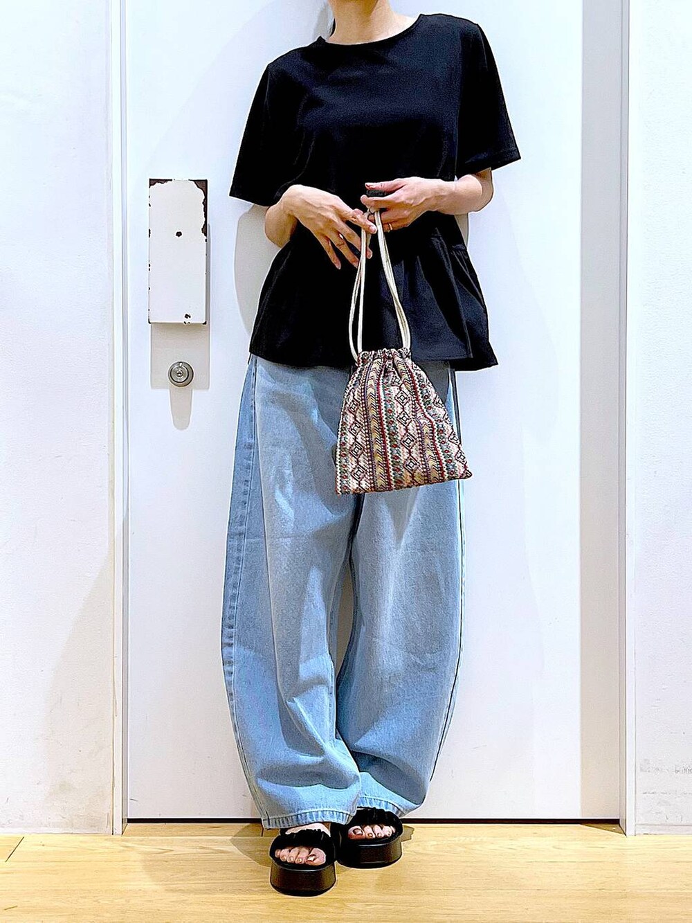 ピンク系のショルダーバッグ、ブルー系のデニムパンツ、ブラック系のTシャツ/カットソーを着用したレディースの夏コーディネートの6枚目の写真