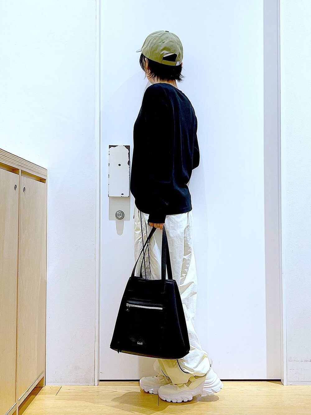 ホワイト系のスニーカー、ベージュ系のその他パンツ、ブラック系のトートバッグを着用したレディースの秋コーディネートの3枚目の写真