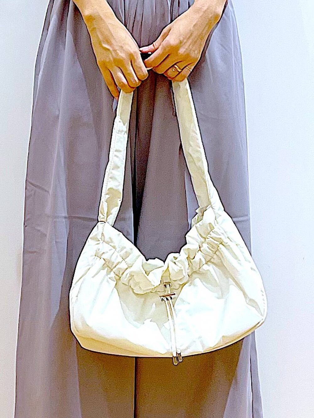 ホワイト系のハンドバッグ、グレー系のその他パンツ、シルバー系のパンプスを着用したレディースの秋コーディネートの9枚目の写真