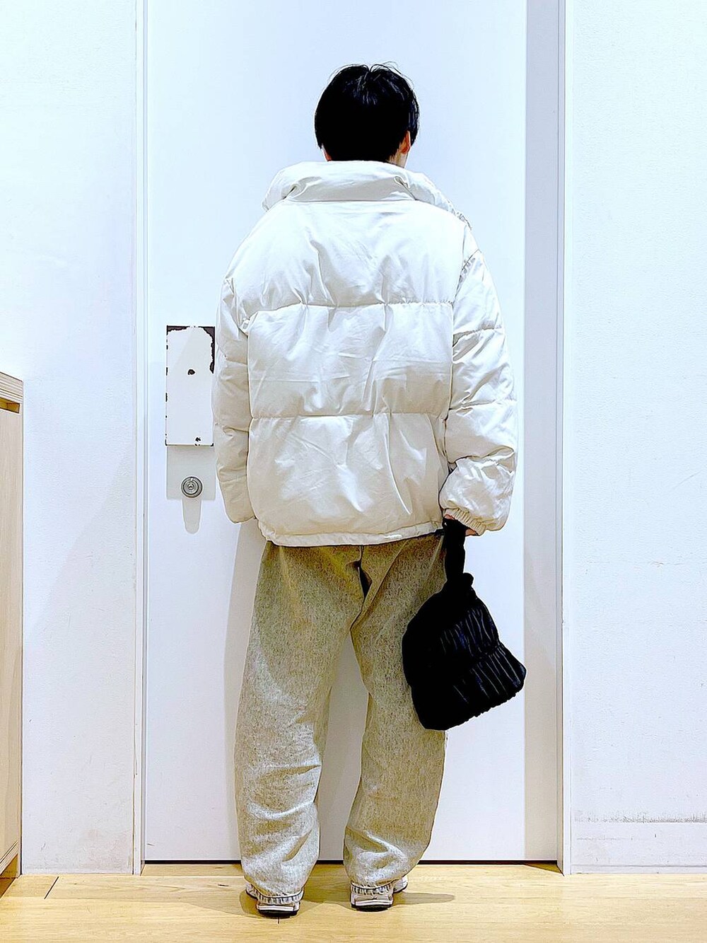 ベージュ系のブルゾン、ブラック系のショルダーバッグ、ベージュ系のデニムパンツを着用したレディースの冬コーディネートの5枚目の写真