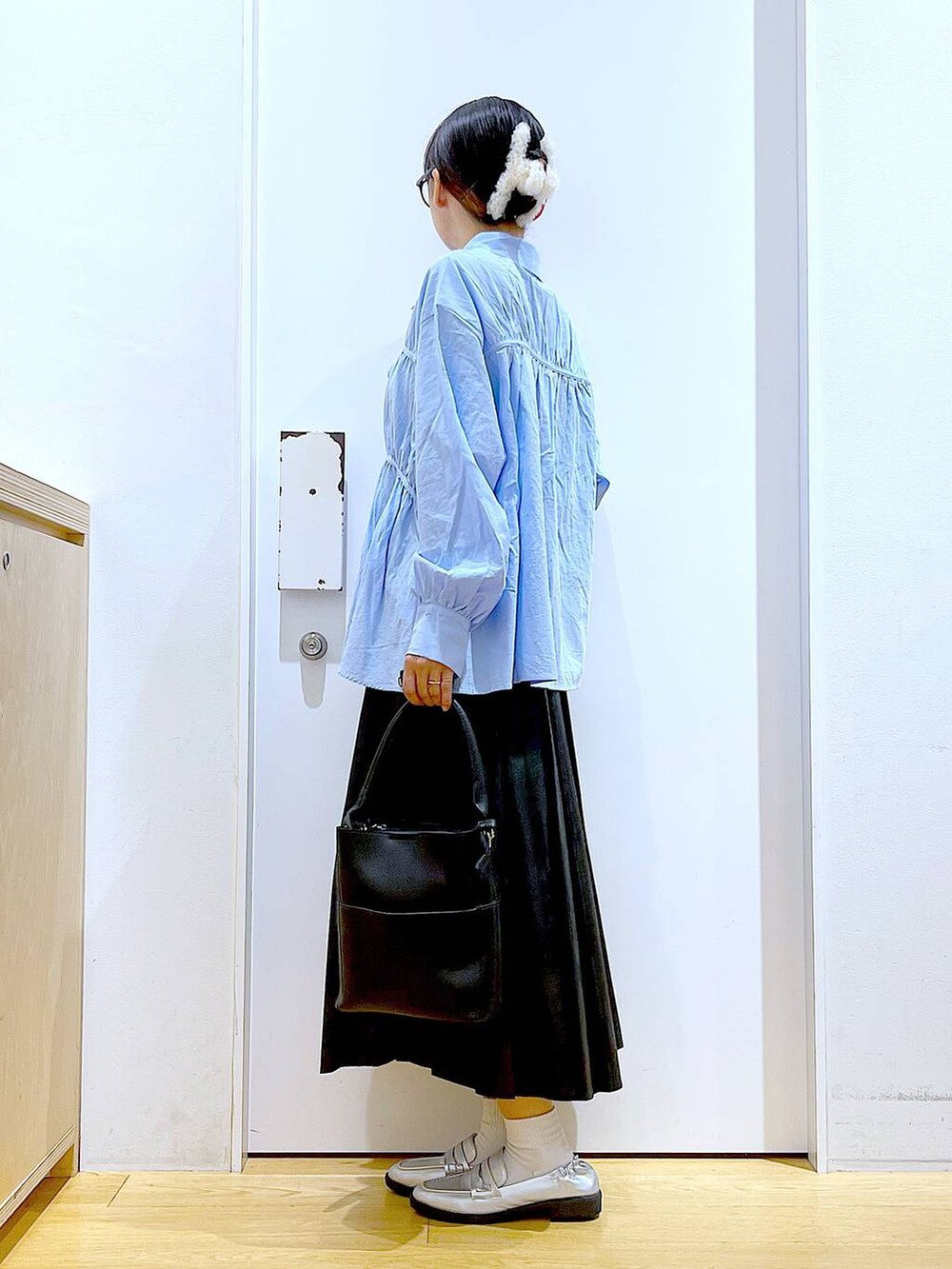 シルバー系のローファー、ブラック系のショルダーバッグ、ブルー系のシャツ/ブラウスを着用したレディースの秋コーディネートの3枚目の写真