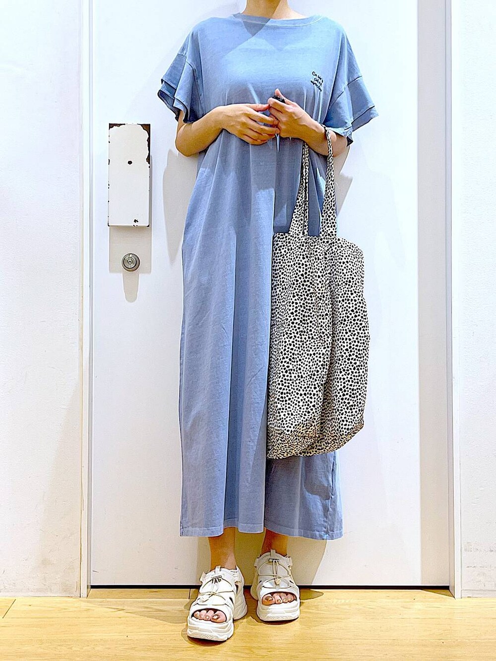 ホワイト系のサンダル、ベージュ系のトートバッグ、ブルー系のワンピースを着用したレディースの夏コーディネートの6枚目の写真