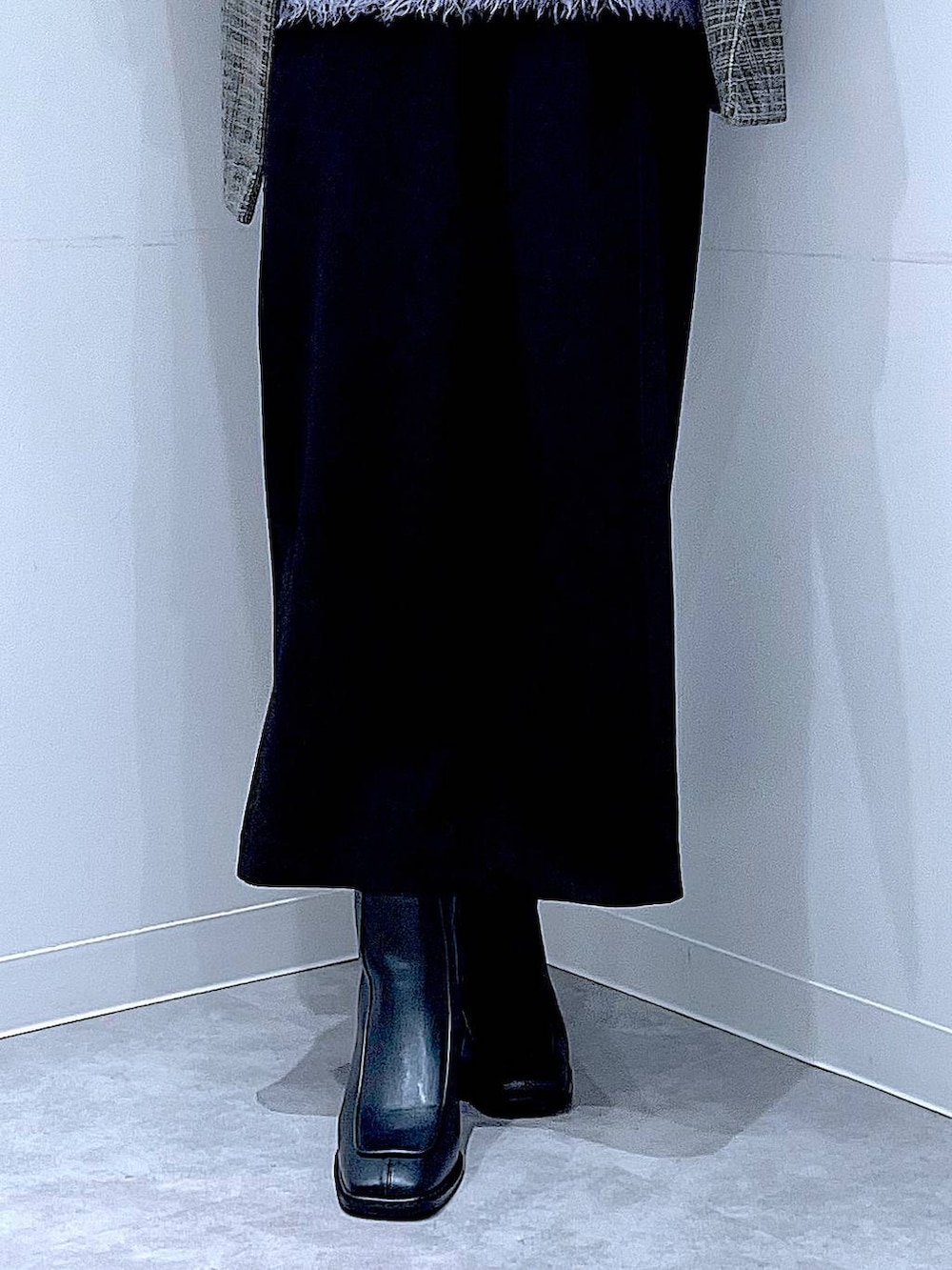 ブラック系のショルダーバッグ、ブラック系のスカート、ブラック系のブーツを着用したレディースの冬コーディネートの8枚目の写真