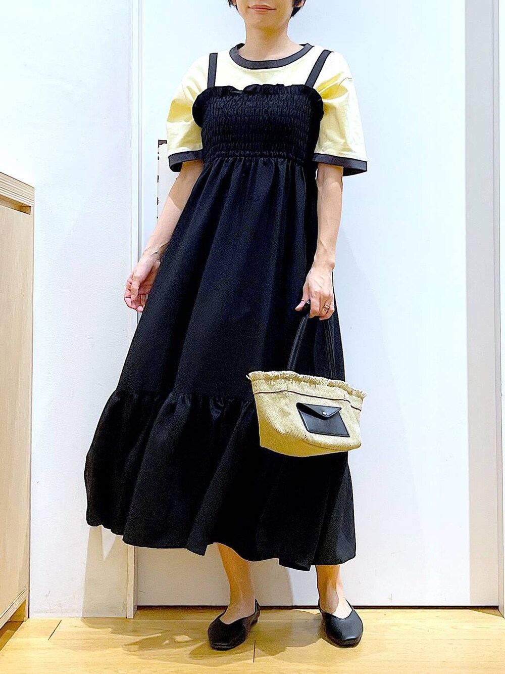 ブラック系のパンプス、ベージュ系のショルダーバッグ、ブラック系のワンピースを着用したレディースの夏コーディネートの6枚目の写真
