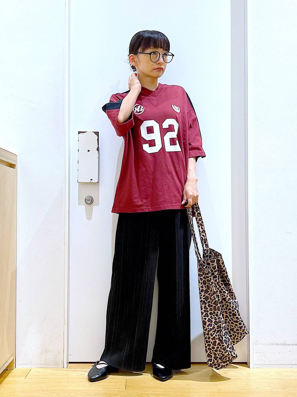 ブラック系のパンプス、ベージュ系のトートバッグ、ブラック系のその他パンツを着用したレディースの夏コーディネートの2枚目の写真