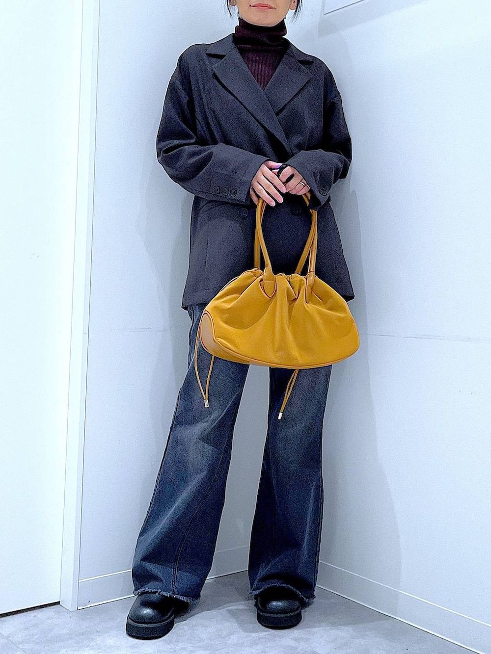 ブラウン系のハンドバッグ、ブラウン系のニット/セーター、グレー系のテーラードジャケットを着用したレディースの冬コーディネートの6枚目の写真