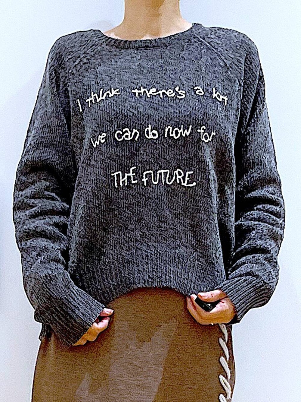 ブラック系のブーツ、ブラック系のショルダーバッグ、ブラウン系のスカートを着用したレディースの冬コーディネートの7枚目の写真