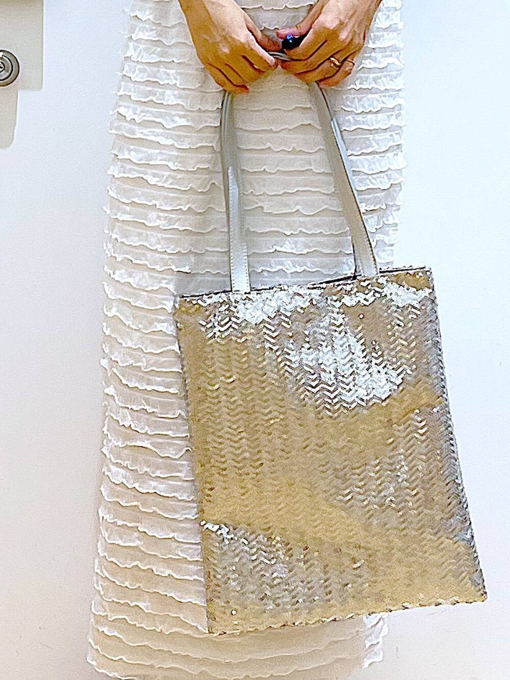 ホワイト系のサンダル、シルバー系のトートバッグ、ホワイト系のスカートを着用したレディースの秋コーディネートの9枚目の写真