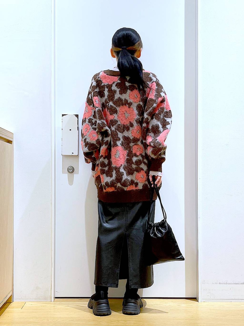 グレー系のTシャツ/カットソー、ブラック系のブーツ、ブラック系のスカートを着用したレディースの冬コーディネートの5枚目の写真