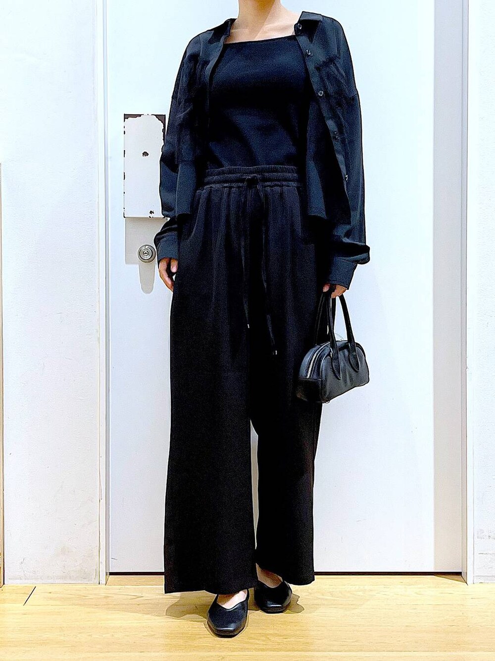 ブラック系のボストンバッグ、ブラック系のその他パンツ、ブラック系のパンプスを着用したレディースの春コーディネートの6枚目の写真