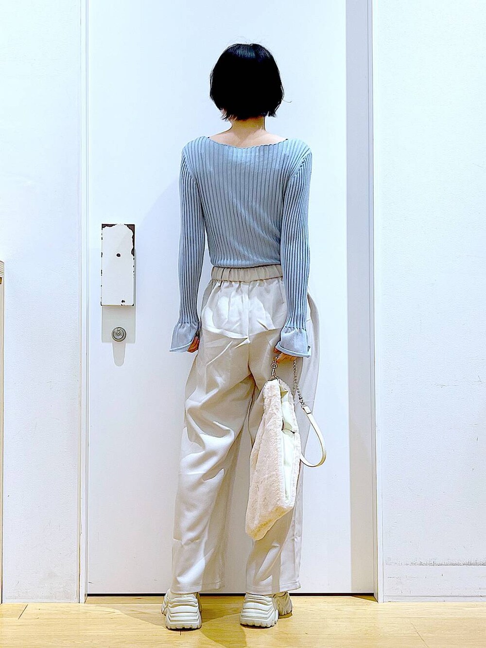 ブルー系のニット/セーター、ホワイト系のショルダーバッグ、ベージュ系のブーツを着用したレディースの冬コーディネートの5枚目の写真