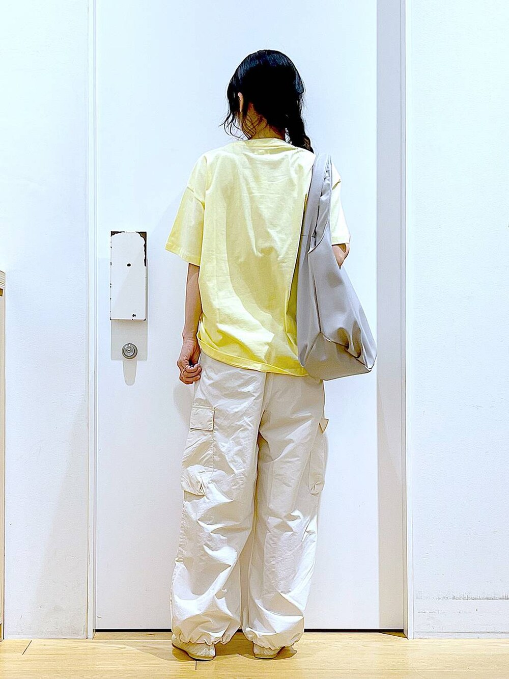 グレー系のトートバッグ、ホワイト系のカーゴパンツ、ホワイト系のパンプスを着用したレディースの春コーディネートの5枚目の写真