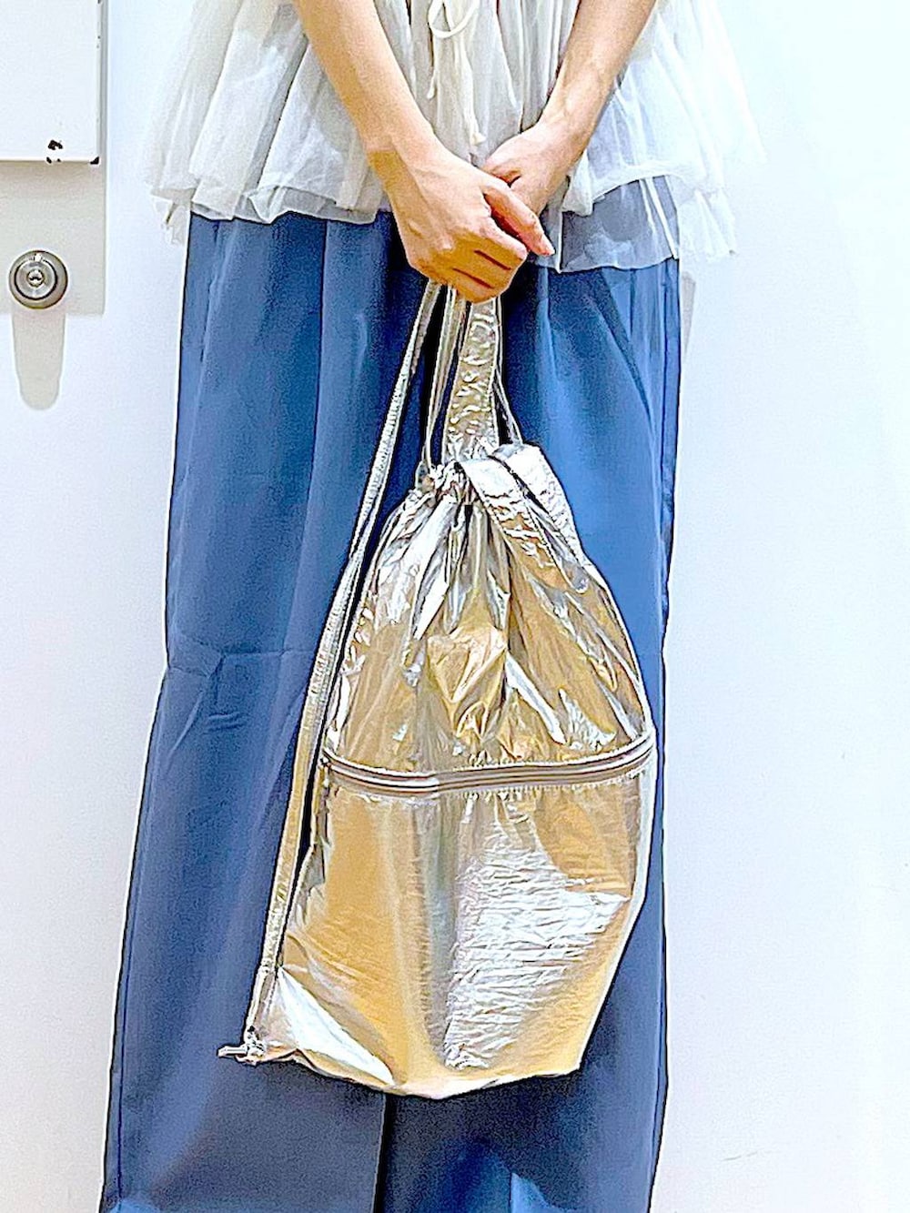 シルバー系のバックパック/リュック、ホワイト系のTシャツ/カットソー、シルバー系のサンダルを着用したレディースの夏コーディネートの9枚目の写真