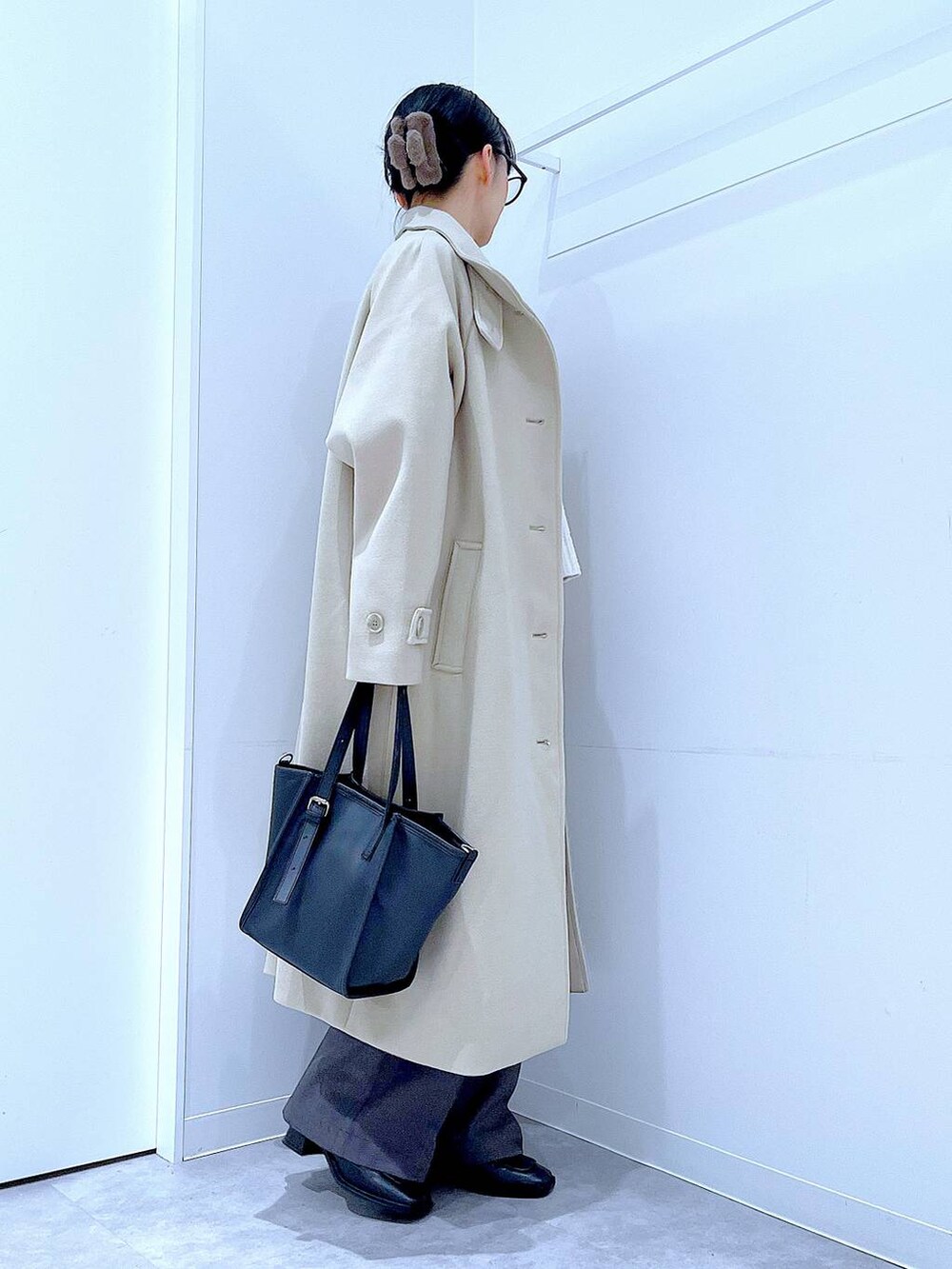 ベージュ系のその他アウター、ブラック系のブーツ、グレー系のスラックスを着用したレディースの冬コーディネートの4枚目の写真