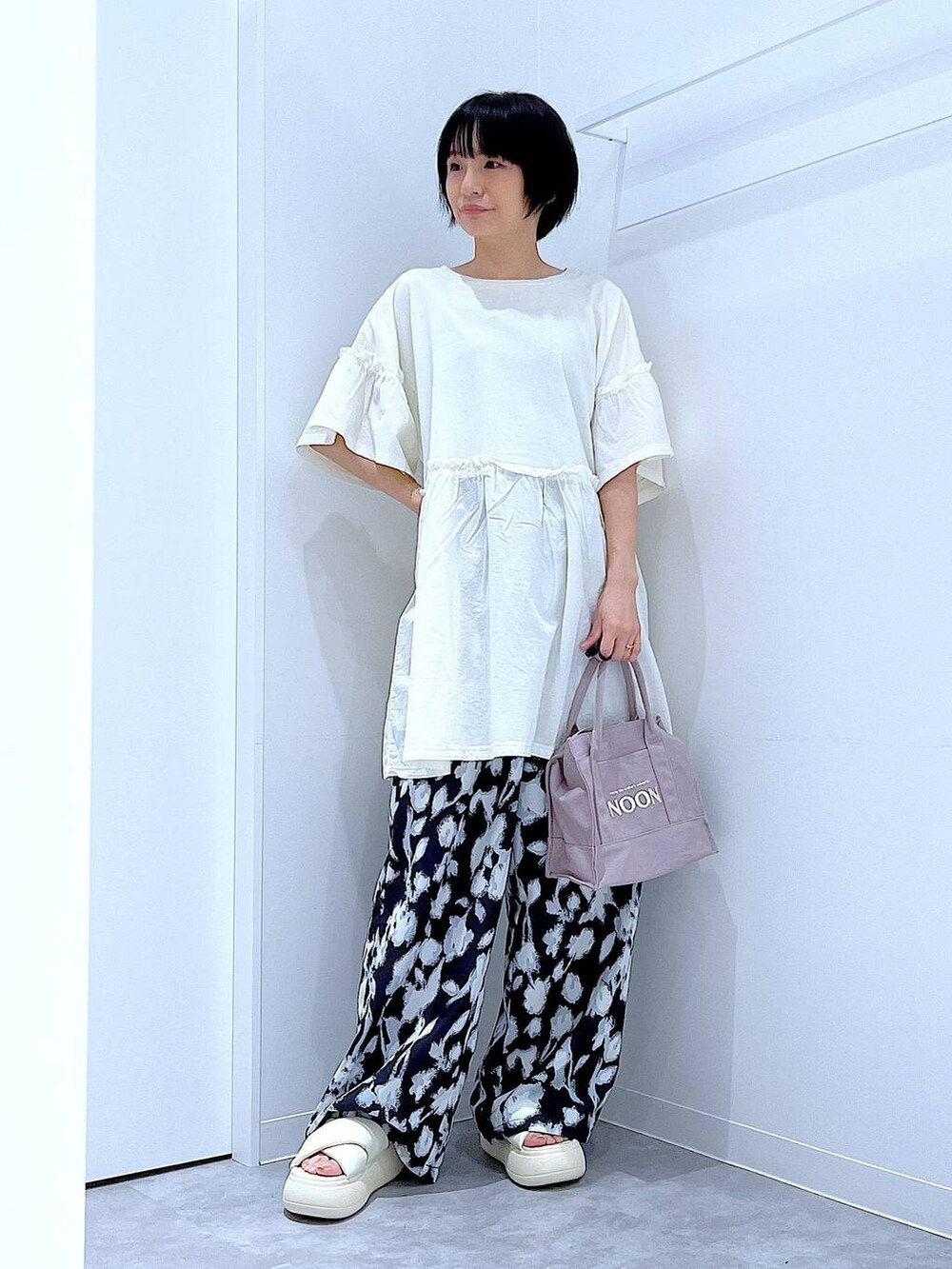 ホワイト系のサンダル、ブラック系のその他パンツ、グレー系のトートバッグを着用したレディースの夏コーディネートの2枚目の写真