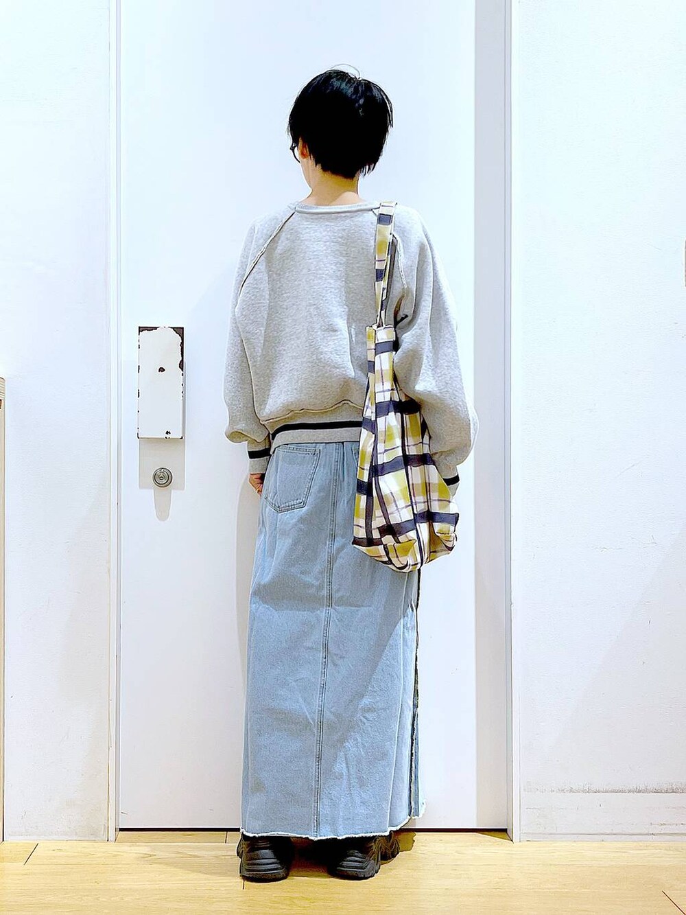 ブルー系のデニムスカート、その他のトートバッグ、ブラック系のブーツを着用したレディースの冬コーディネートの5枚目の写真