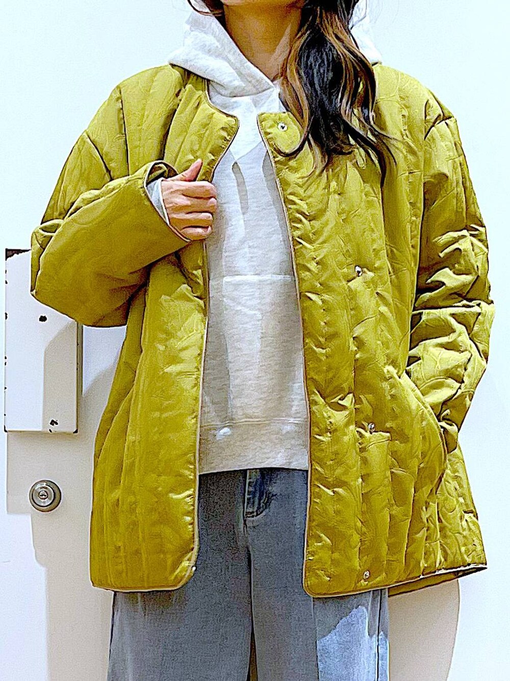 ブルー系のデニムパンツ、ベージュ系のブーツ、ベージュ系のパーカーを着用したレディースの冬コーディネートの7枚目の写真