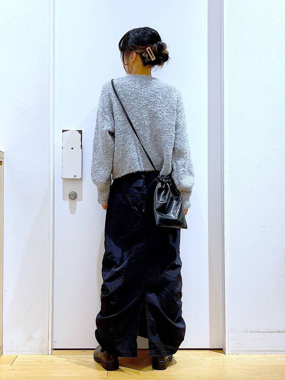 ブラック系のブーツ、ブラック系のスカート、ブラック系のショルダーバッグを着用したレディースの冬コーディネートの5枚目の写真