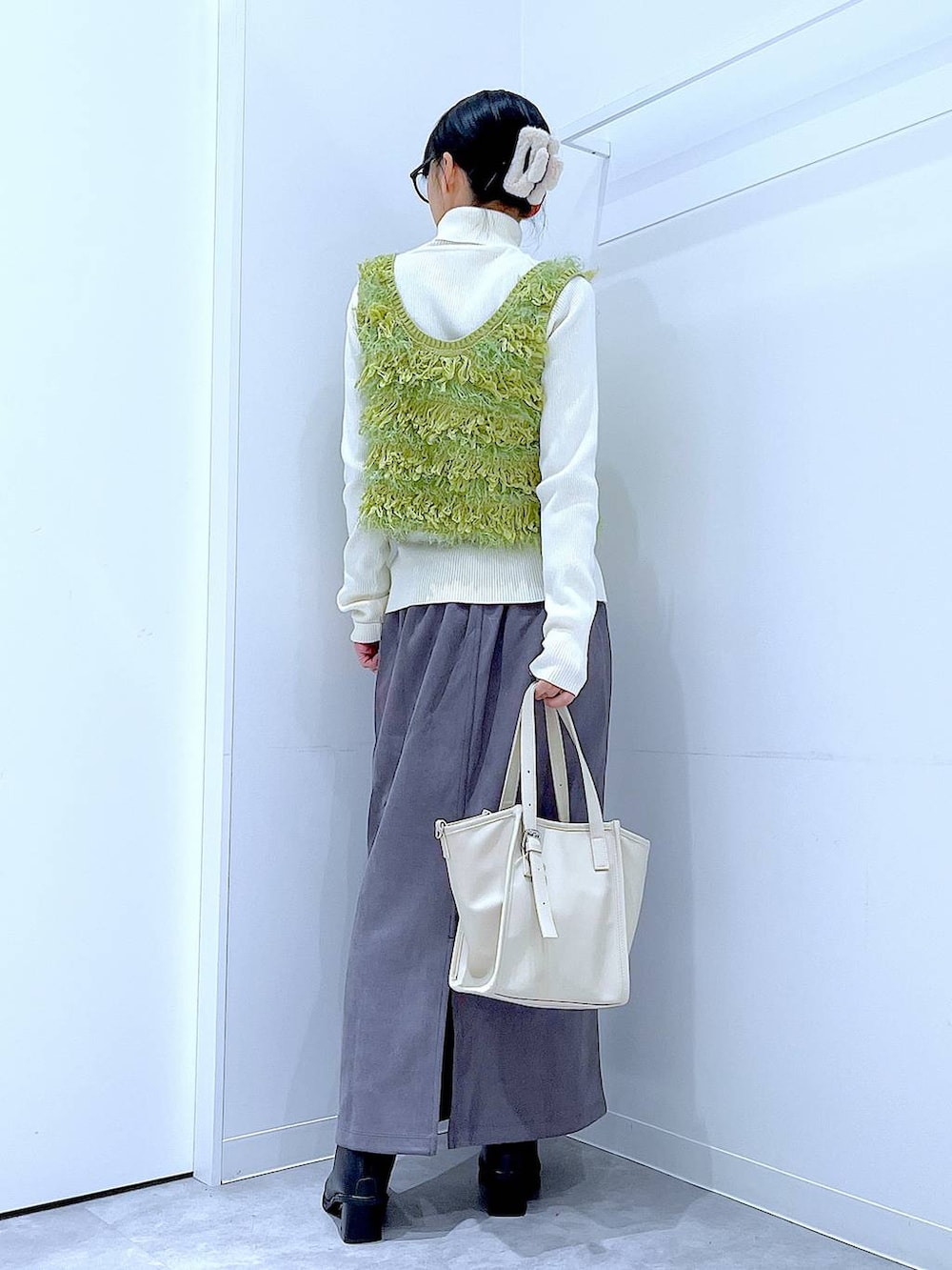 ブラック系のブーツ、グレー系のスカート、ベージュ系のニット/セーターを着用したレディースの冬コーディネートの5枚目の写真